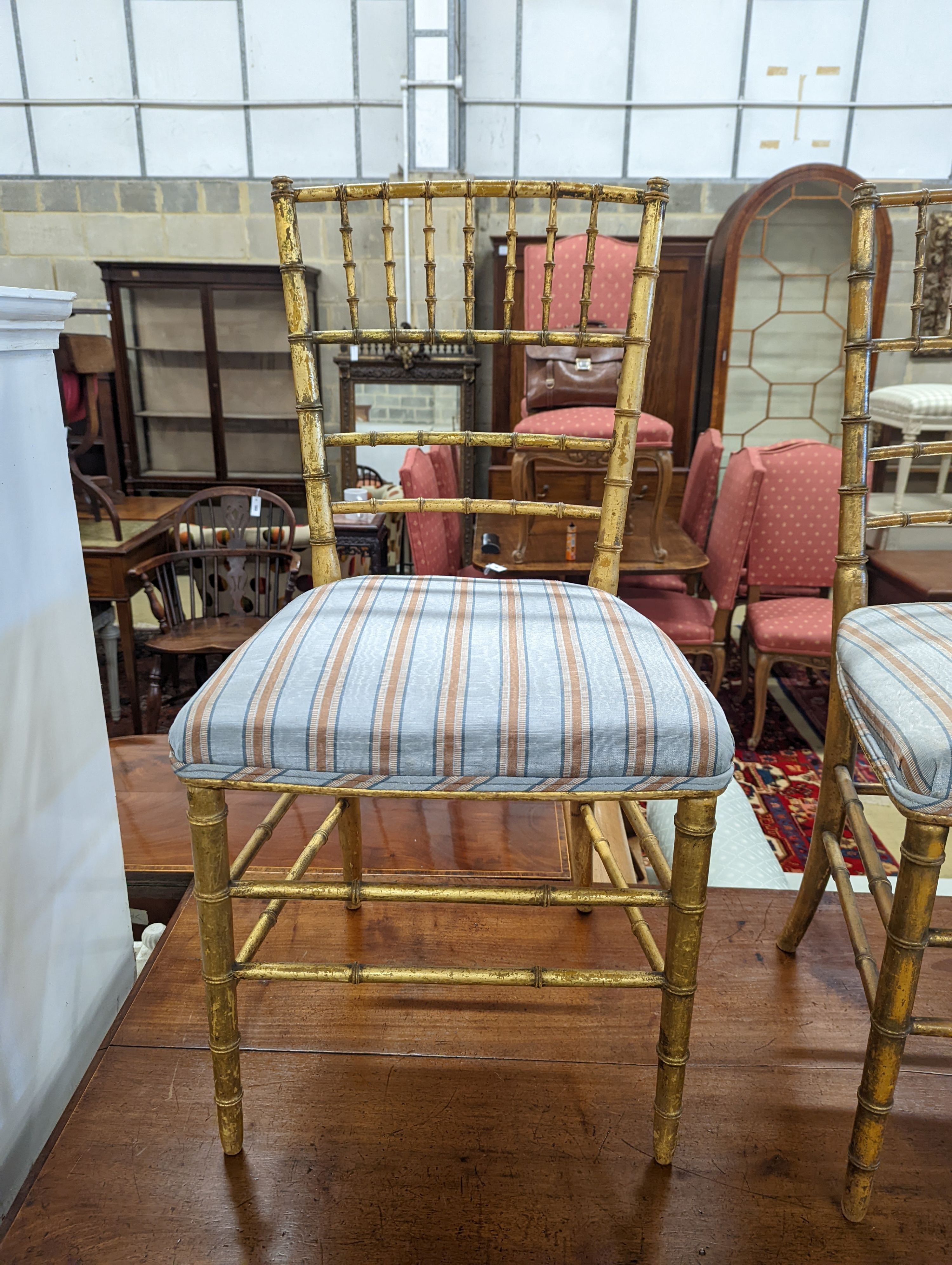 A pair of Regency simulated bamboo gilt wood side chairs with striped seats